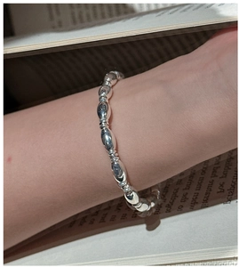 S925 sterling silver beaded bracelet with oval metallic beads shown on a wrist