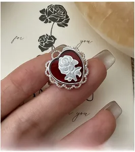 Macro shot of S925 silver ring featuring red heart cameo with a white rose relief