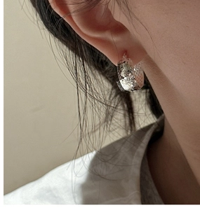 Close-up of S925 sterling silver hoop earring with textured hammered finish on ear