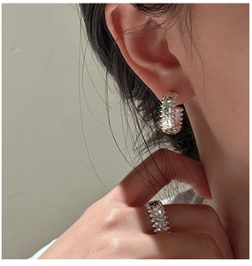 Detail of S925 silver ring and hoop earrings featuring industrial rivet textures