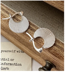 Macro shot of S925 sterling silver pleated earrings with fine textured radial folds