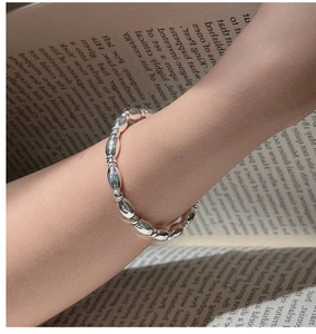 Detail of S925 sterling silver beaded bracelet with sleek oval beads on a model wrist