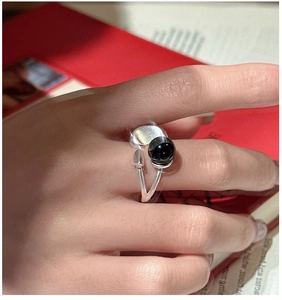 Detailed view of an S925 sterling silver open ring with a black agate sphere on a red book