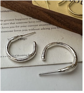 Detail of S925 sterling silver hoop earrings with organic lava texture and hallmark