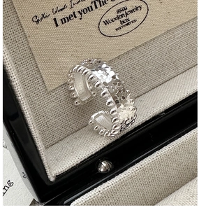 Macro shot of S925 silver ring with hammered texture and beaded edge in a jewelry box