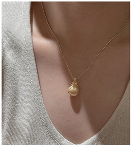 Detail of S925 sterling silver lucky bag pendant necklace on neck with matte gold finish
