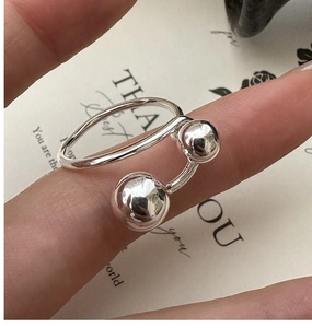Macro detail of S925 sterling silver minimalist double bead open ring on finger