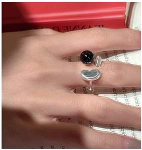 Detail view of S925 sterling silver ring with black agate and bean design on model hand
