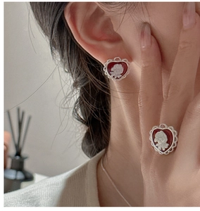 Close-up of vintage heart-shaped cameo earrings and ring set with rose relief