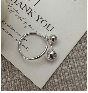 Detailed view of S925 sterling silver open ring with polished beads on a card