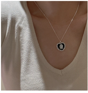 Détail du collier cœur en argent S925 avec rose camée sur mannequin en tricot beige chic