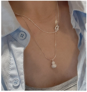 Detailed close-up of double-layered silver Wu Lou pendant necklace on a female model