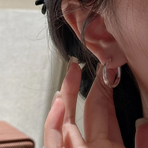 Elegant S925 sterling silver hoop earrings with twisted texture worn by a model