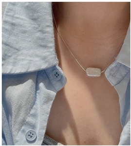 Detail of S925 sterling silver necklace with baroque pearl pendant on model neck