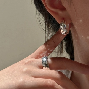 S925 sterling silver hoop earring and wide ring set with hammered texture in sunlight