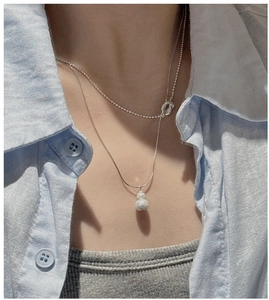 Detail of layered S925 silver necklaces with gourd pendant and knot design on neck