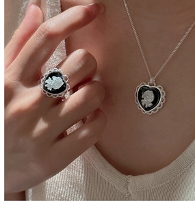 Gros plan d'un ensemble collier et bague en argent S925 avec relief de camée fleuri