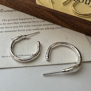 S925 sterling silver hoop earrings with unique lava texture on a wooden block