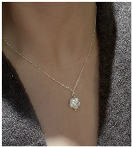 Détail macro du collier en argent S925 avec pendentif fleur en perle baroque sur pull
