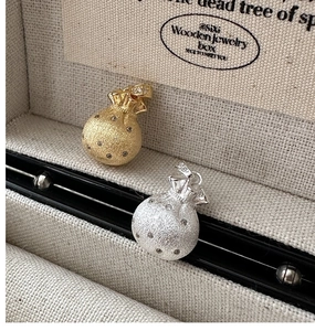 Macro view of gold and silver S925 sterling silver lucky bag pendants with matte finish