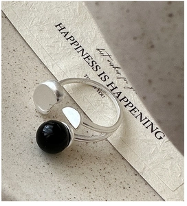 Macro shot of S925 sterling silver ring featuring a black agate bead and engraved logo