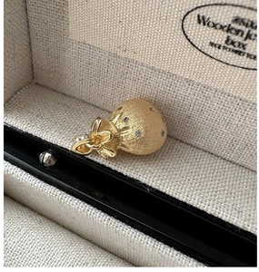 Macro shot of gold fortune bag pendant with frosted texture and zircon butterfly knot