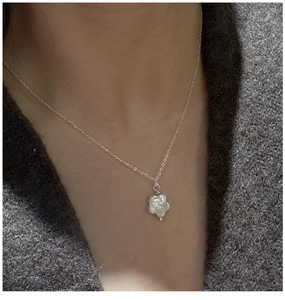 Gros plan du collier fleur en argent S925 avec perle baroque porté par le mannequin
