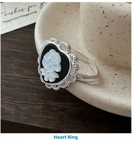Macro detail of S925 silver heart ring featuring a vintage cameo rose on black enamel