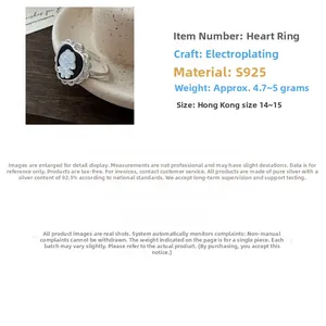 Macro detail of S925 sterling silver heart ring with white floral cameo and black inlay