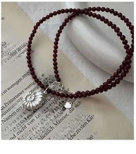 Detail of vintage silver conch pendant with red agate beads on a retro book background