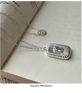 Macro shot of S925 sterling silver rectangular pendant with zircon on book pages