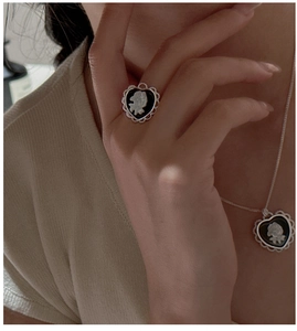 Close-up of vintage heart-shaped ring and necklace set with white rose cameo