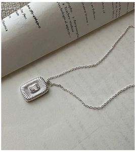 Detail of S925 silver necklace with rectangular radiant texture and zircon pendant