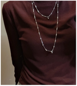 Detailed close-up of S925 sterling silver bamboo joint chain necklace on a sweater