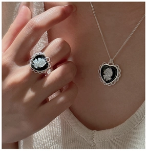 Detail of vintage S925 silver heart ring and necklace set with rose cameo relief