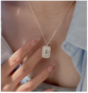 Macro detail of S925 sterling silver necklace with vintage square zircon pendant on model