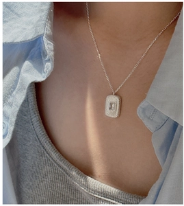 Close-up of S925 silver necklace featuring a square sunburst pendant with zircon stone