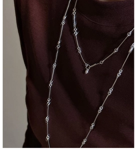 Detailed view of layered S925 sterling silver bamboo chain with a water drop pendant
