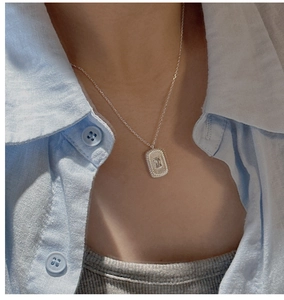Close-up of S925 silver necklace with rectangular zircon pendant on a fashion model
