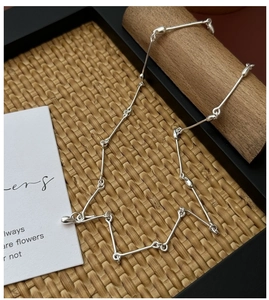 Detail view of S925 sterling silver bamboo chain with teardrop charms on dark tray