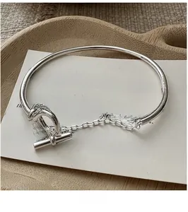 Close-up of S925 sterling silver OT buckle bracelet on minimalist decorative background