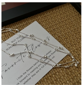 Detail of S925 sterling silver bamboo style necklace on a minimalist poetic card