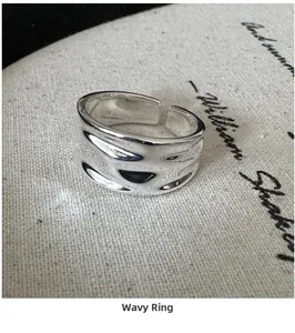 Macro view of wide silver ring with liquid metal texture on vintage script background