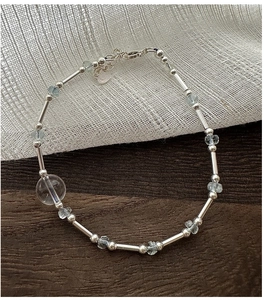 Macro detail of S925 silver beaded bracelet featuring aquamarine gems and crystal