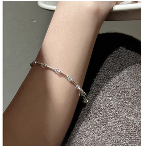 Macro detail of S925 sterling silver bracelet with aquamarine crystal on a model arm
