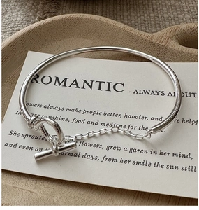 Macro detail of S925 sterling silver OT bracelet with toggle clasp on wooden tray