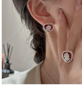 Detail of vintage red cameo heart earrings and ring with lace silver edges on model