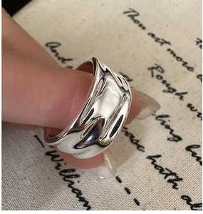 Macro shot of S925 sterling silver wide ring with liquid wavy texture and polished finish