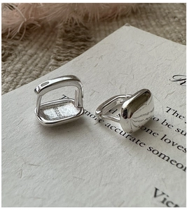 Vue macro des boucles d'oreilles créoles carrées minimalistes en argent S925 avec poinçon