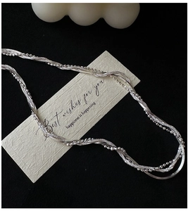 Détail du collier multicouche en argent S925 avec chaîne serpent et perles sur carte